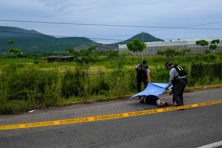 Guardias Nacionales Mexicanos cubren un cuerpo hallado tirado al costado de una carretera en Culiacán, Sinaloa. Foto AP