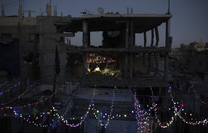 Palestinos cuelgan luces por Ramadan, en sus casas arrasadas en Gaza. Foto: AP