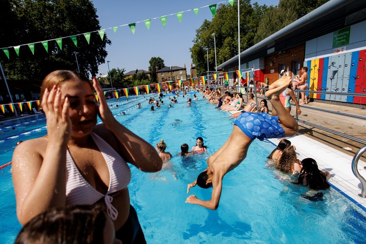Británicos se refrescan en una pileta en Londres. Foto: EFE
