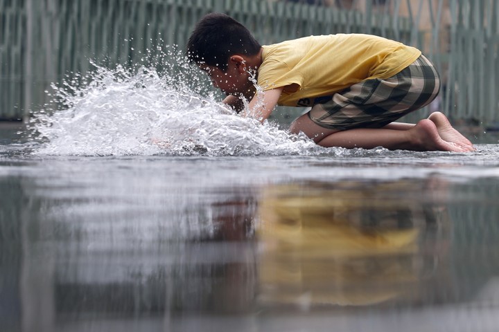 Un niño juega en el agua, en París. Foto: EFE