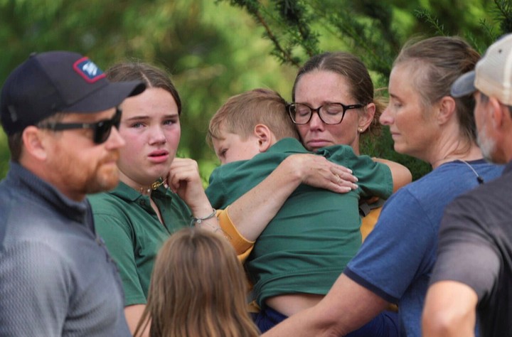 Niños con sus padres, tras el tiroteo. Foto: AP
